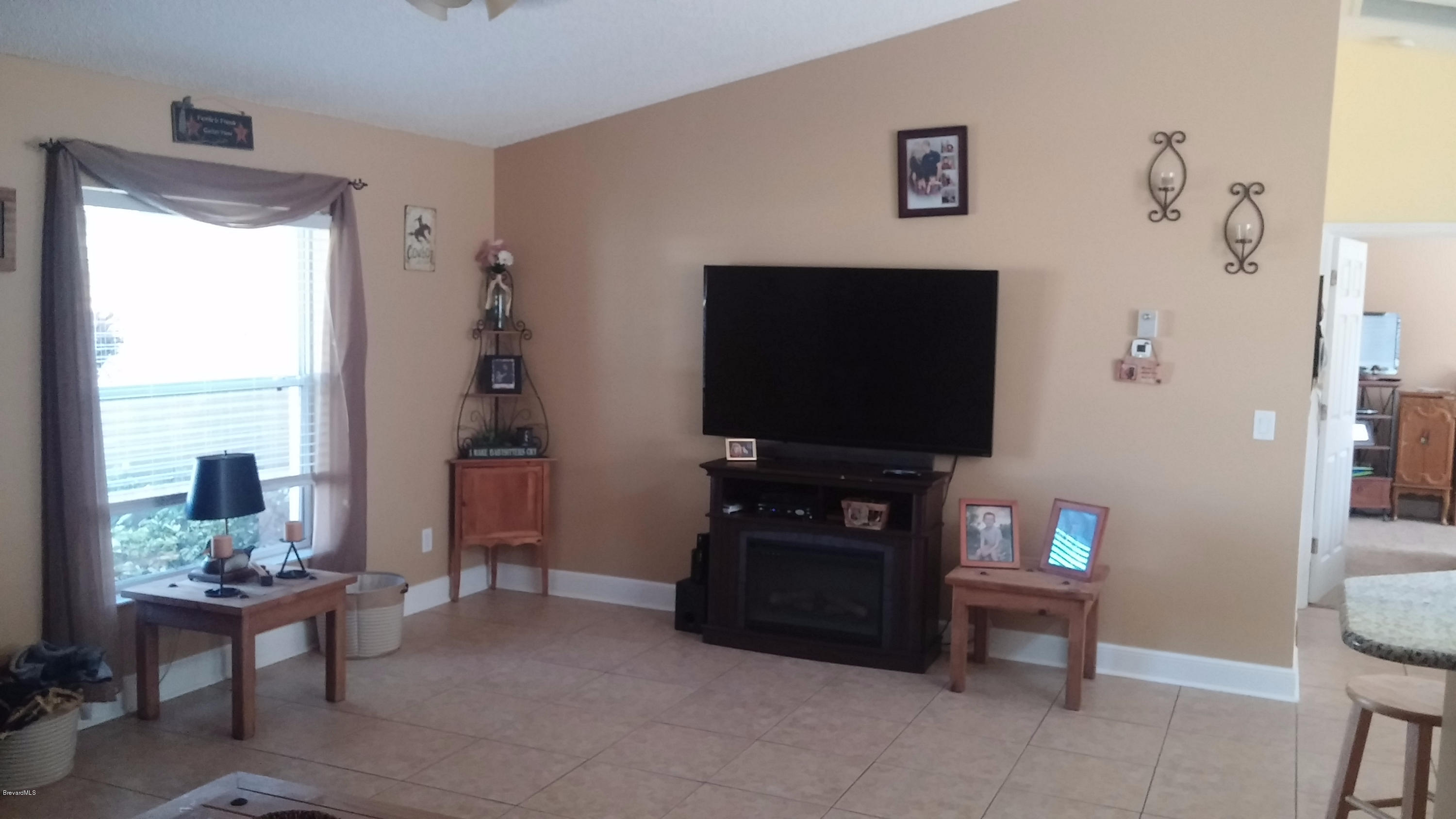 6950 Bryant Road Cocoa, FL 32927 - Photo 4 of 20 a living room with furniture and a flat screen tv