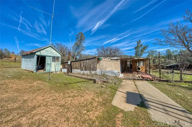 a view of a house with backyard and wooden fence
