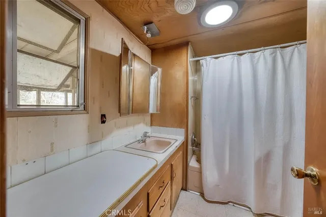 a bed sitting in a spacious bedroom next to a window