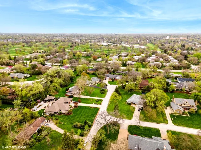 an aerial view of residential houses with outdoor space and trees