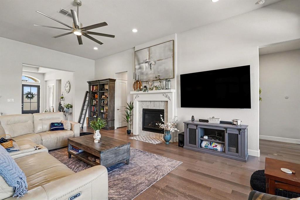 573 Broadleaf Way Haslet, TX 76052 - Photo 15 of 35 a living room with furniture a flat screen tv and a fireplace