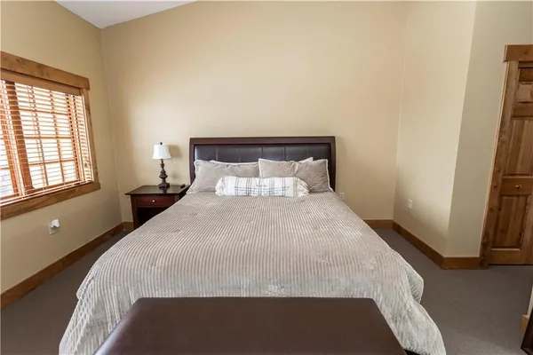 a spacious bedroom with a bed and a flat screen tv