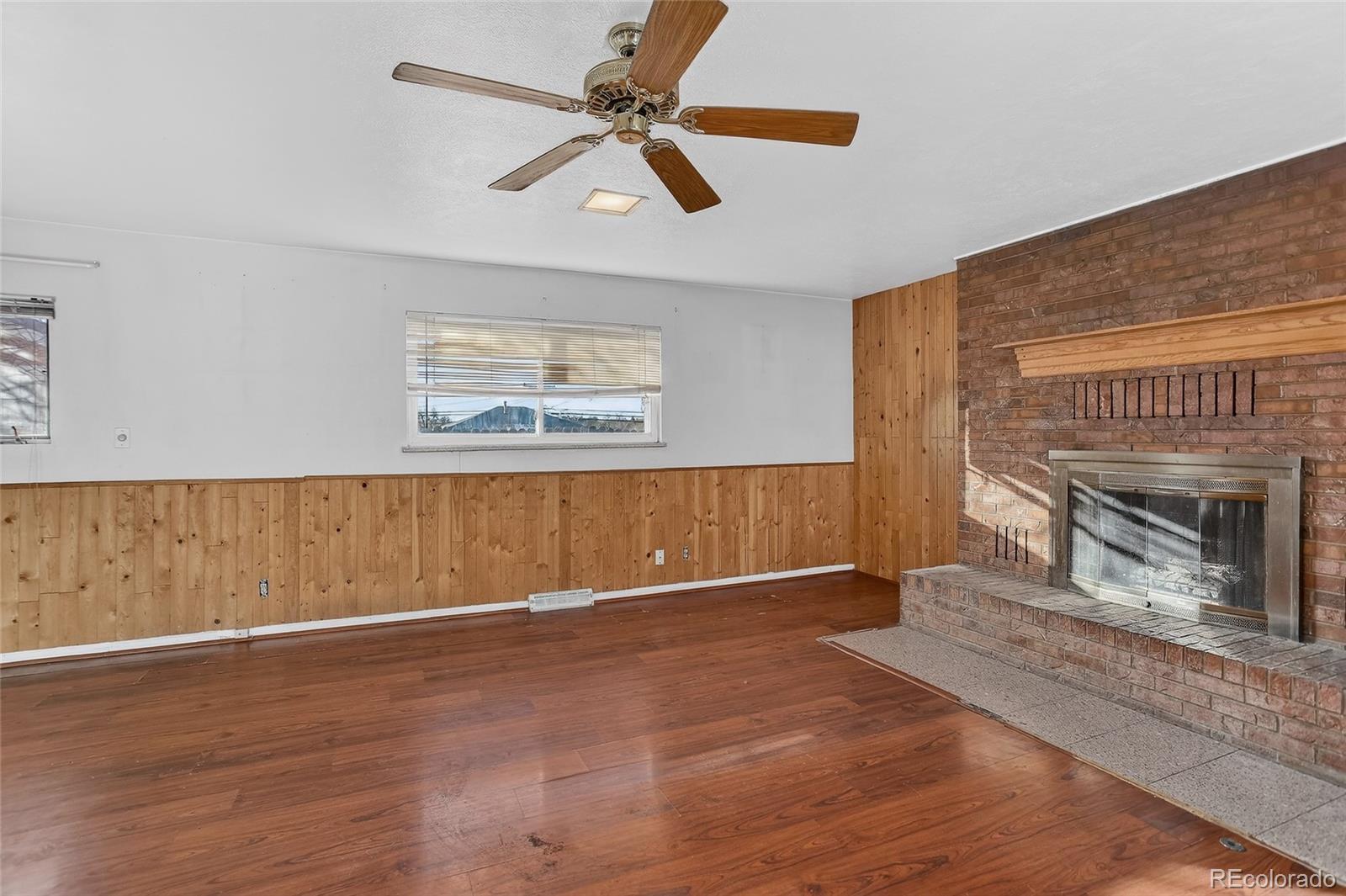 1279 South Raritan Street Denver, CO 80223 - Photo 11 of 21 a view of an empty room with wooden floor fireplace and a window