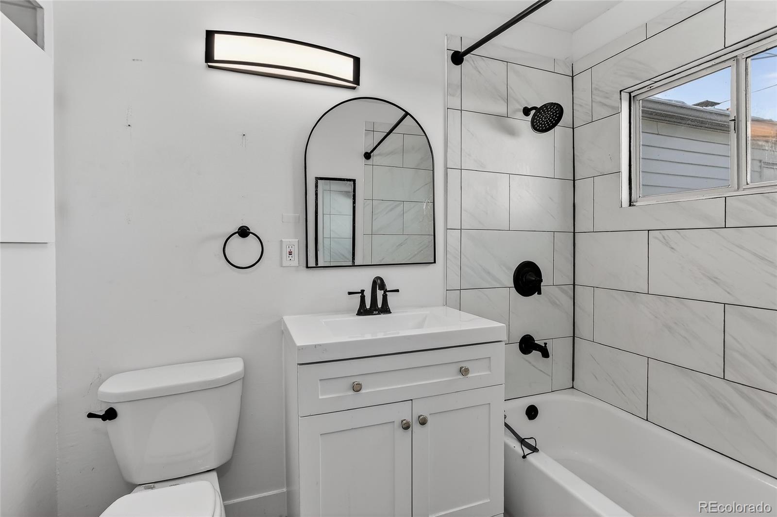 1279 South Raritan Street Denver, CO 80223 - Photo 16 of 21 a bathroom with a sink toilet and shower