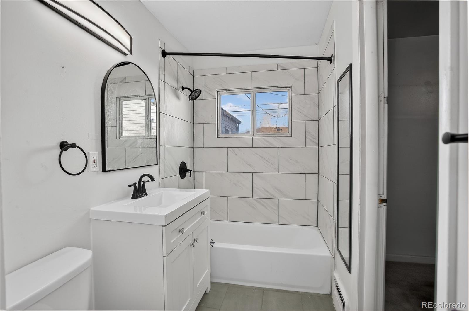 1279 South Raritan Street Denver, CO 80223 - Photo 17 of 21 a bathroom with a sink a toilet and a bathtub