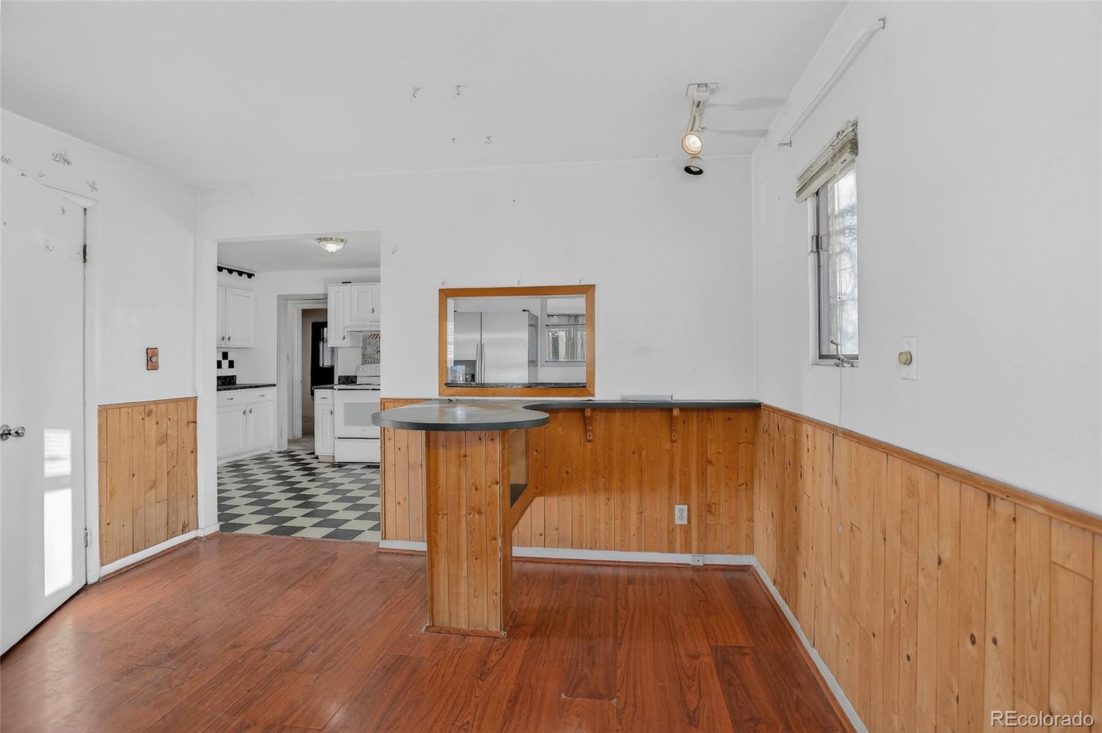 1279 South Raritan Street Denver, CO 80223 - Photo 7 of 21 a view of a hallway with wooden floor and a bathroom