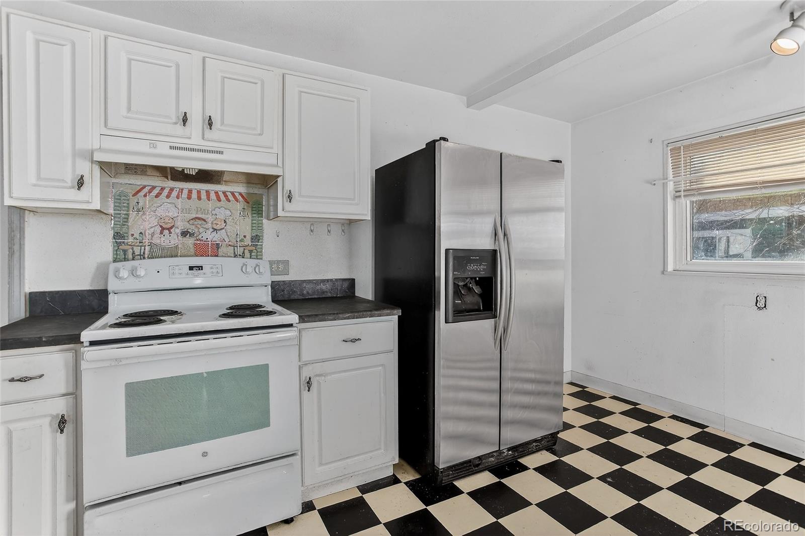 1279 South Raritan Street Denver, CO 80223 - Photo 9 of 21 a kitchen with a stove a refrigerator and cabinets