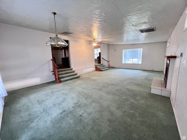 479 East 100 N Road Meadow, UT 84644 - Photo 4 of 59 Unfurnished living room featuring a ceiling fan, light carpet, and a fireplace
