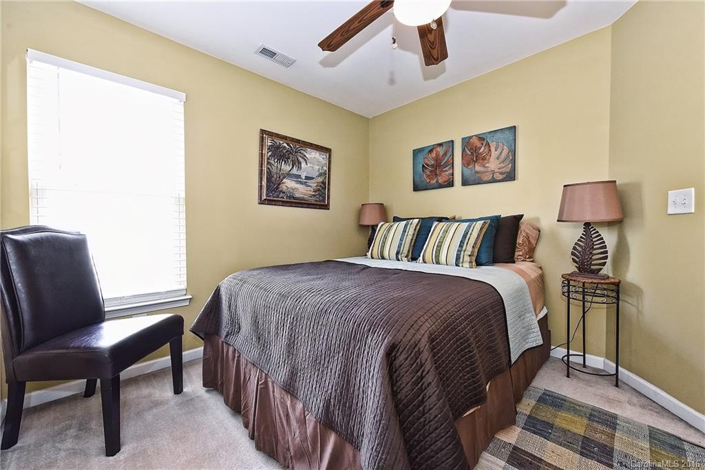 8905 Washam Potts Road Cornelius, NC 28031 - Photo 17 of 24 a bedroom with a bed and a chair