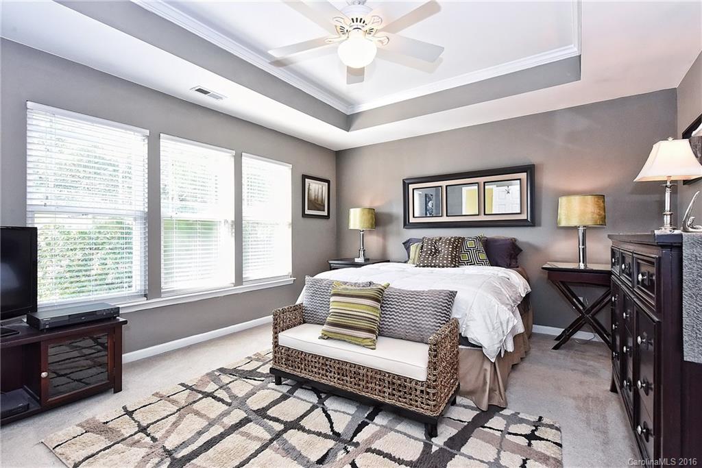 8905 Washam Potts Road Cornelius, NC 28031 - Photo 19 of 24 a bedroom with a bed and a chandelier