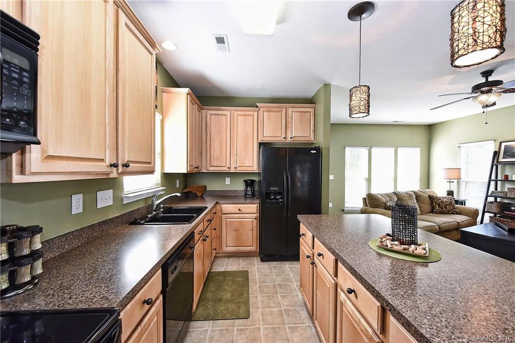 8905 Washam Potts Road Cornelius, NC 28031 - Photo 3 of 24 a kitchen with stainless steel appliances granite countertop a sink a stove and a refrigerator