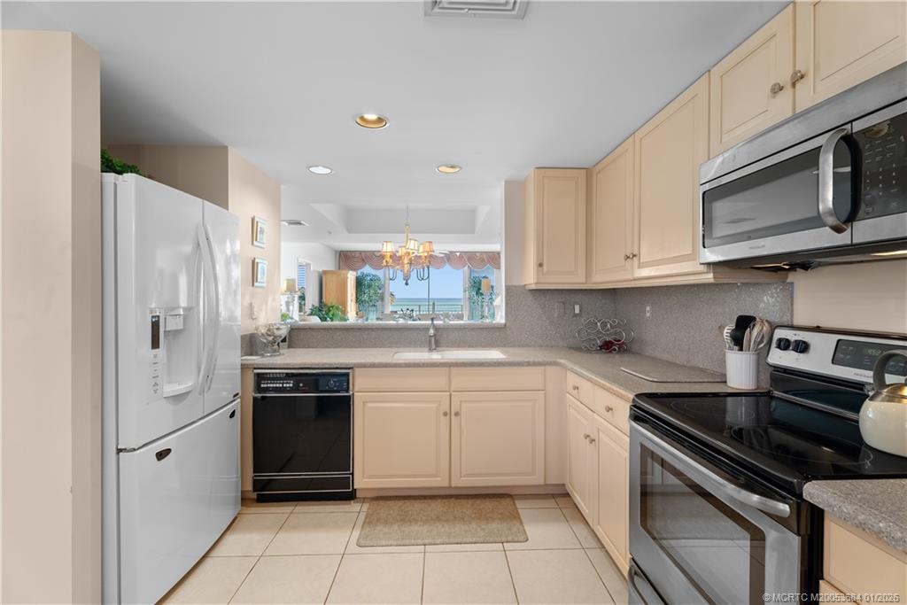 579 Northeast Plantation Road, Unit N202 Jensen Beach, FL 34957 - Photo 27 of 42 a kitchen with stainless steel appliances white cabinets and a stove top oven