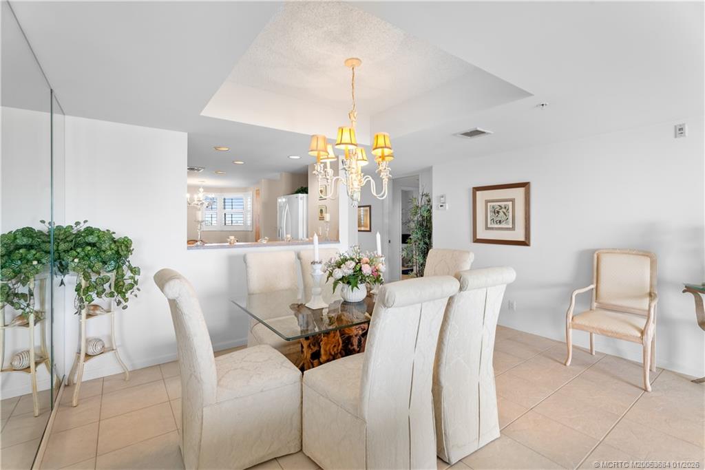 579 Northeast Plantation Road, Unit N202 Jensen Beach, FL 34957 - Photo 31 of 42 a view of a dining room with furniture and a chandelier