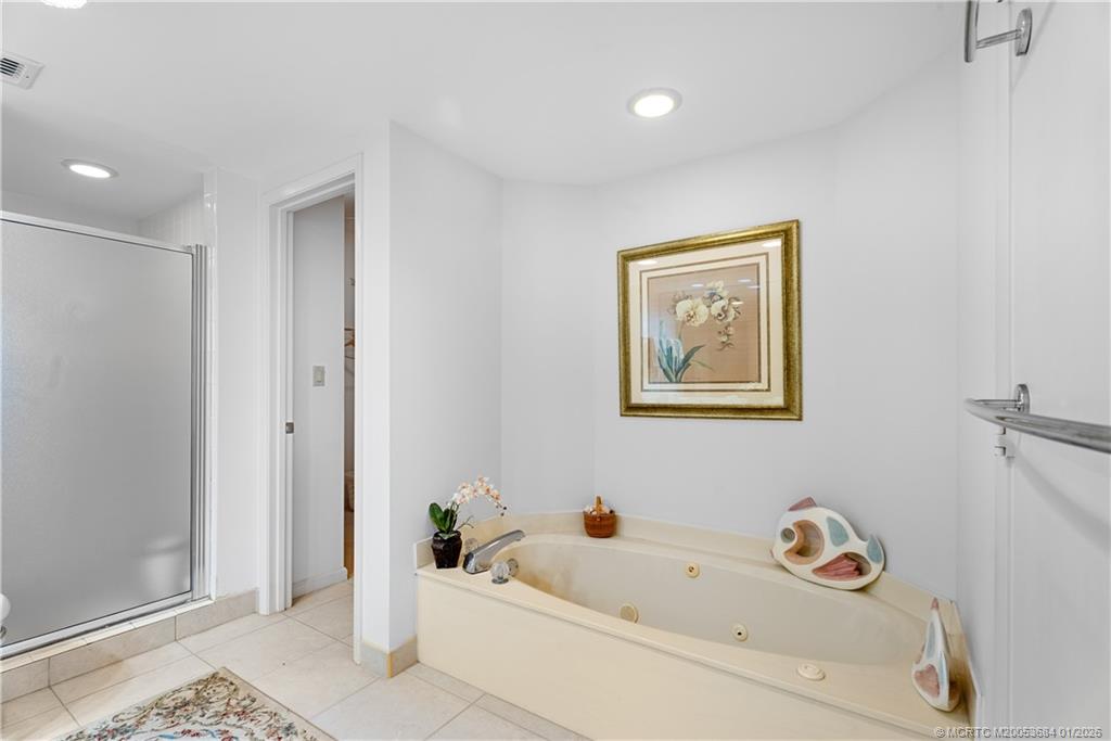 579 Northeast Plantation Road, Unit N202 Jensen Beach, FL 34957 - Photo 35 of 42 a bathroom with a bathtub and a window