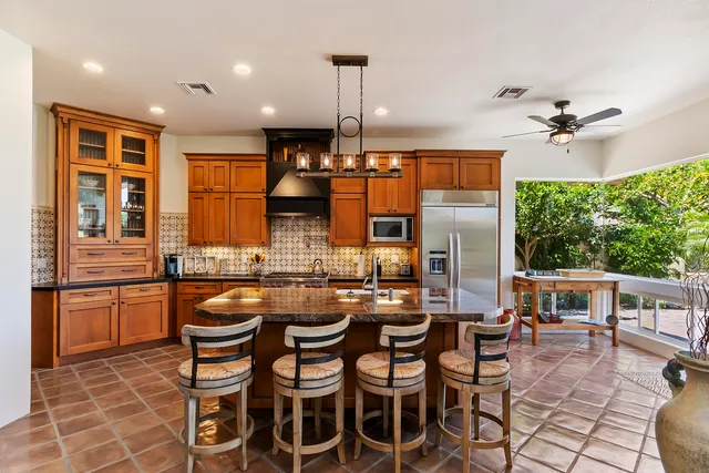 a dining hall with stainless steel appliances a stove a table and chairs