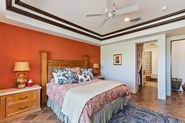 a bedroom with a bed and a lamp on dresser