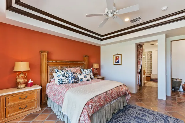 a bedroom with a bed and a lamp on dresser