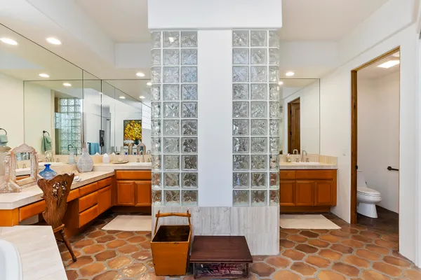 a bathroom with a double vanity sink a toilet and shower