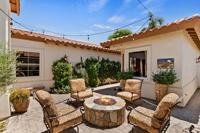 a view of a patio with couches table and chairs and potted plants