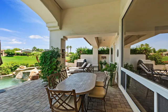 a view of a patio with table and chairs and potted plants