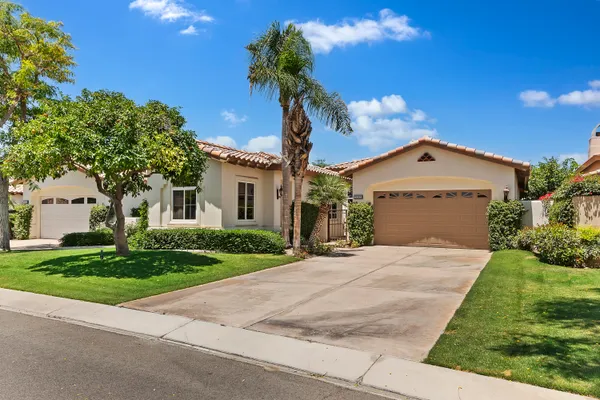 a view of a patio with couches table and chairs under an umbrella