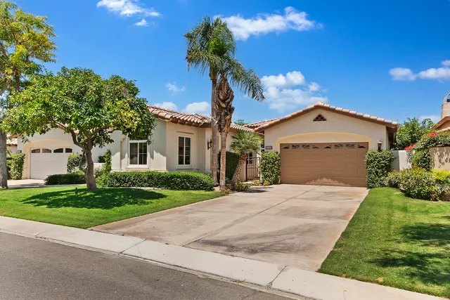 a view of a patio with couches table and chairs under an umbrella