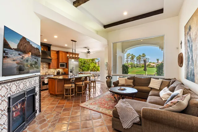 a living room with furniture a fireplace and a floor to ceiling window