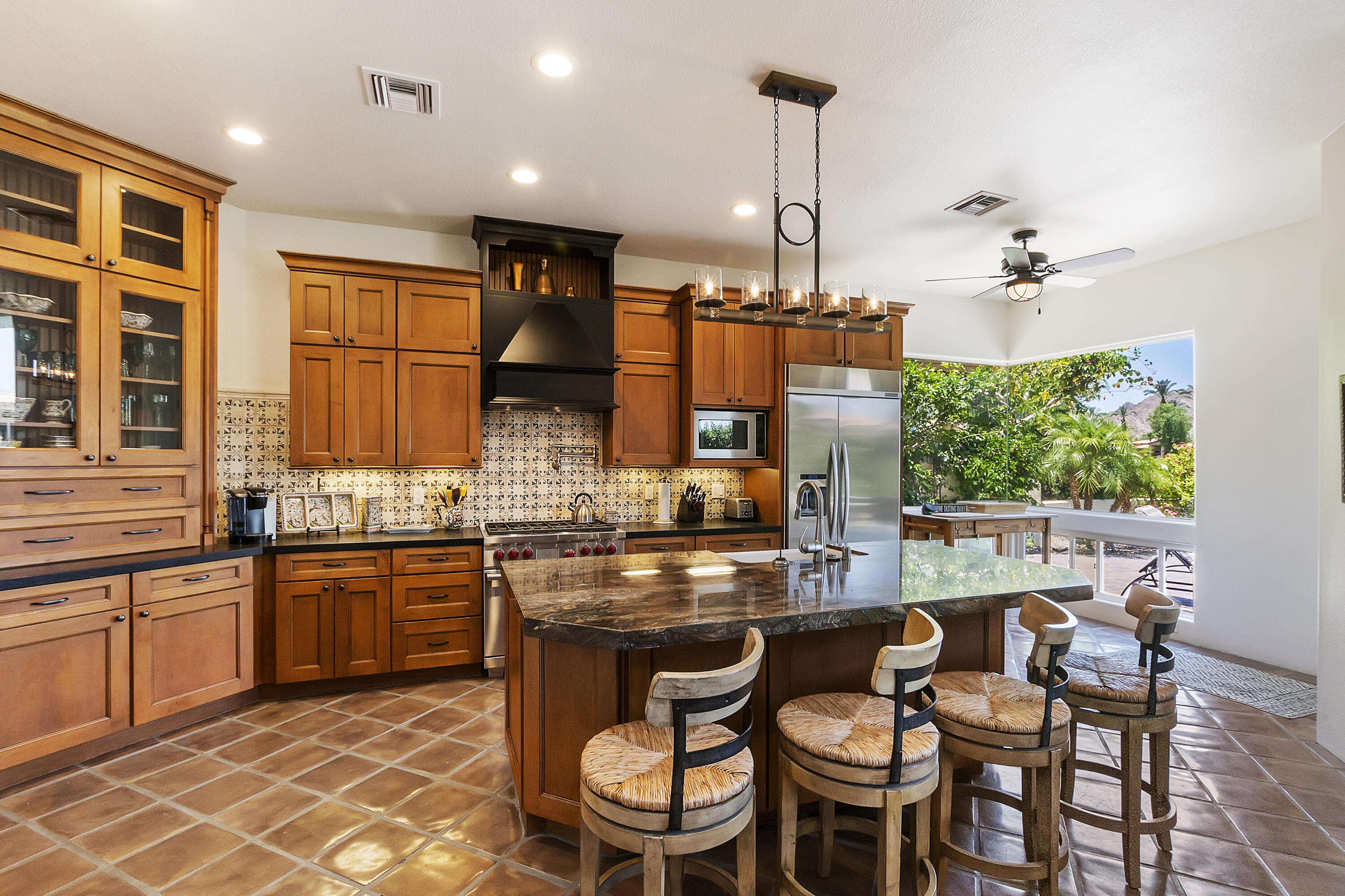 78920 Cabrillo Way La Quinta, CA 92253 - Photo 10 of 41 a kitchen with stainless steel appliances granite countertop a stove a sink dishwasher a dining table and chairs with wooden floor
