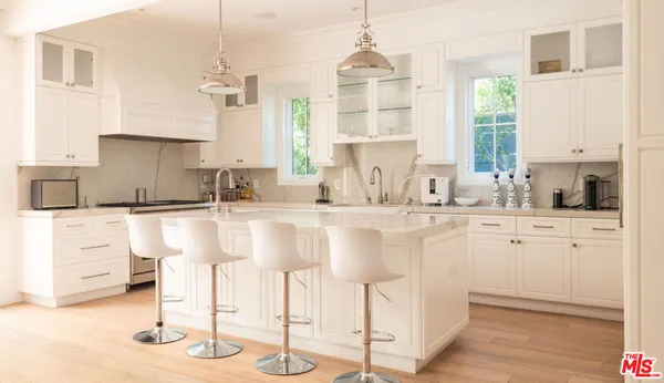 a kitchen with cabinets and chairs