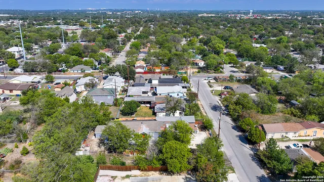 an aerial view of residential houses with outdoor space and trees