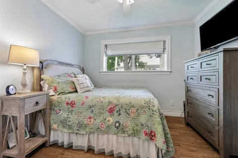 a bedroom with a bed and a flat tv screen on dresser