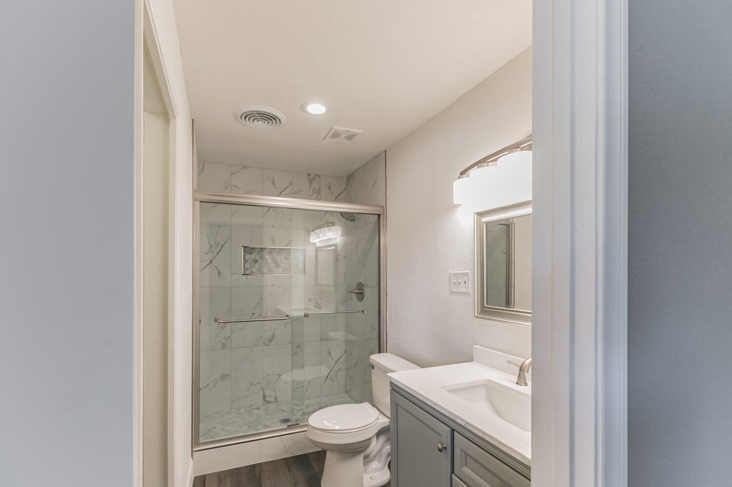 441 Debra Lane Ridgecrest, CA 93555 - Photo 23 of 30 a bathroom with a granite countertop sink a toilet and shower