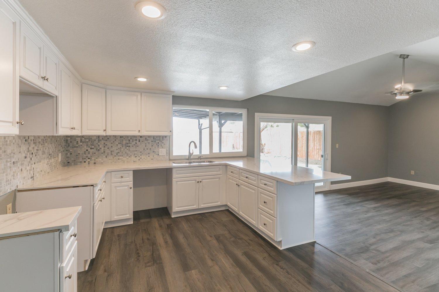 441 Debra Lane Ridgecrest, CA 93555 - Photo 10 of 30 a kitchen with granite countertop white cabinets and white appliances with wooden floor