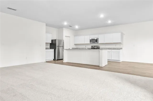 a kitchen with stainless steel appliances granite countertop a refrigerator and a stove top oven
