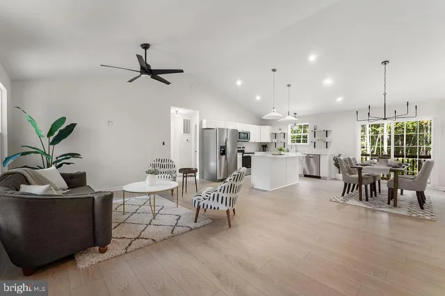 a living room with furniture and a dining table with kitchen view
