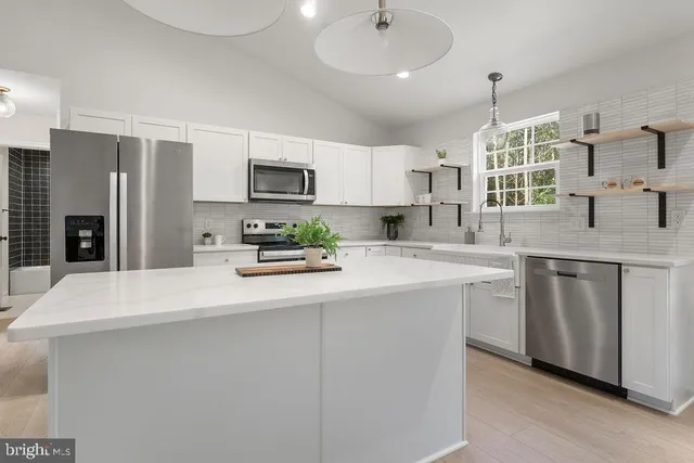 a kitchen with stainless steel appliances a sink stove and refrigerator