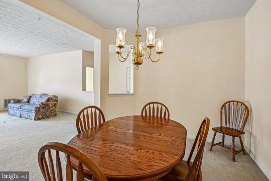 9511 Kingscroft Terrace, Unit 9511F Perry Hall, MD 21128 - Photo 10 of 38 a view of a dining room with furniture wooden floor and chandelier