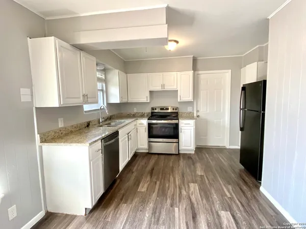 a kitchen with a refrigerator a stove top oven a sink and dishwasher with wooden floor