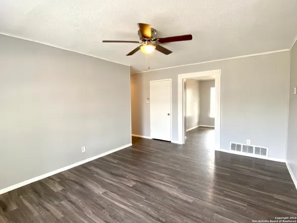 a view of empty room with wooden floor