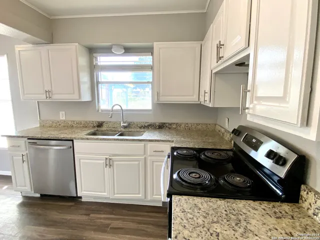 a kitchen with a sink stove and cabinets