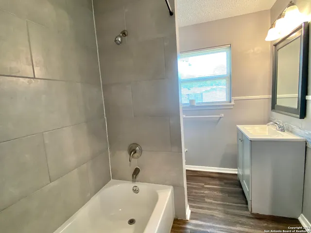 a bathroom with a tub a sink and a window