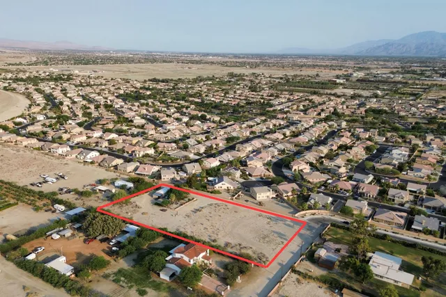 an aerial view of residential houses with outdoor space and trees