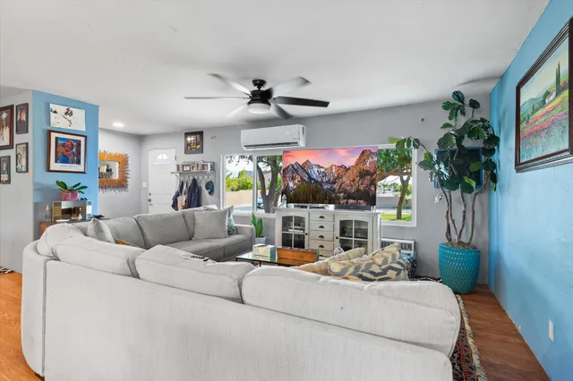 a living room with furniture a flat screen tv and a potted plant