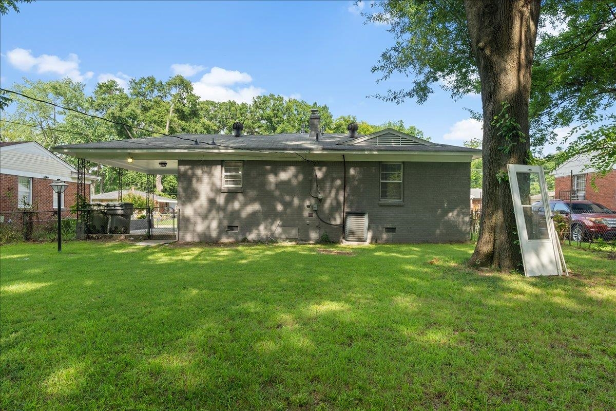 2717 Merle Street Memphis, TN 38118 - Photo 17 of 18 Spacious backyard featuring a covered patio, mature shade tree, and a brick exterior
