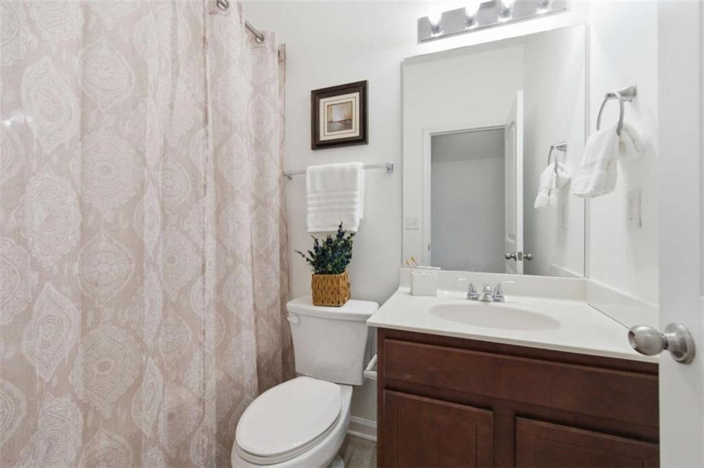 6872 Zaniah Road South Fulton, GA 30331 - Photo 22 of 29 a bathroom with a sink a toilet and shower curtain