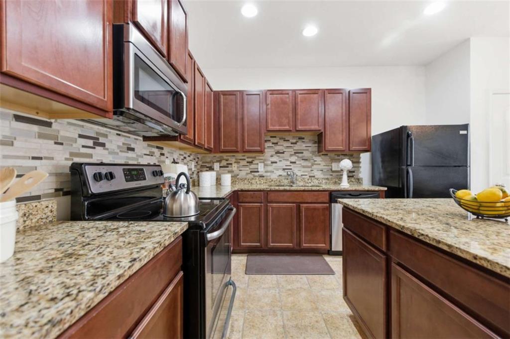 6872 Zaniah Road South Fulton, GA 30331 - Photo 7 of 29 a kitchen with stainless steel appliances granite countertop a sink stove and refrigerator