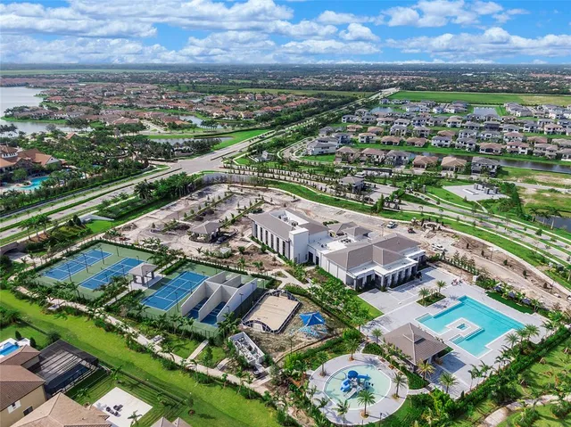 an aerial view of a tennis ground and a cars park