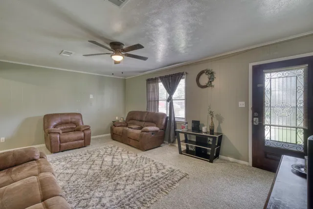 a living room with furniture a ceiling fan and a window
