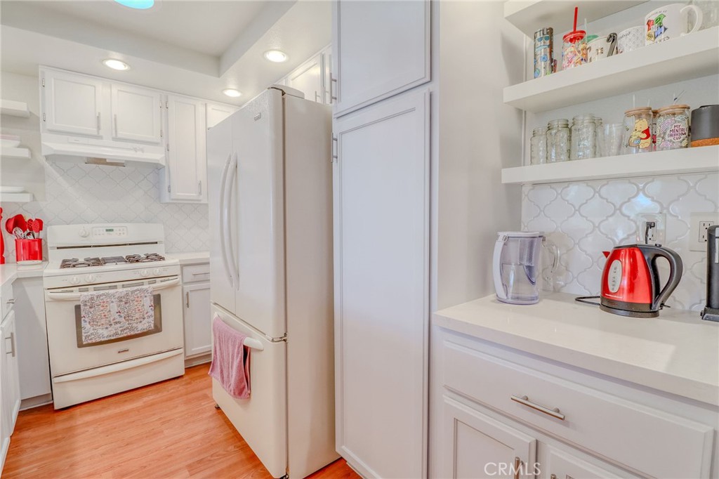 30630 Southern Cross Road Temecula, CA 92592 - Photo 15 of 42 a kitchen with white cabinets and white appliances