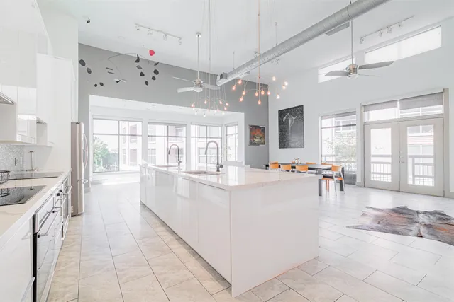a large white kitchen with a large window